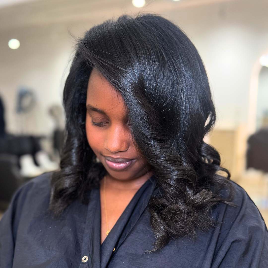 Close-up of silk press process highlighting hair straightening with body and shine.