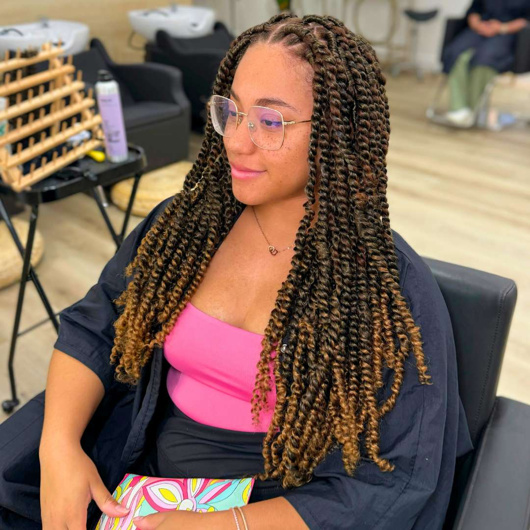 Client flaunting shiny, defined curls and braid-detail protective style after Des Curl Spa Salon treatment