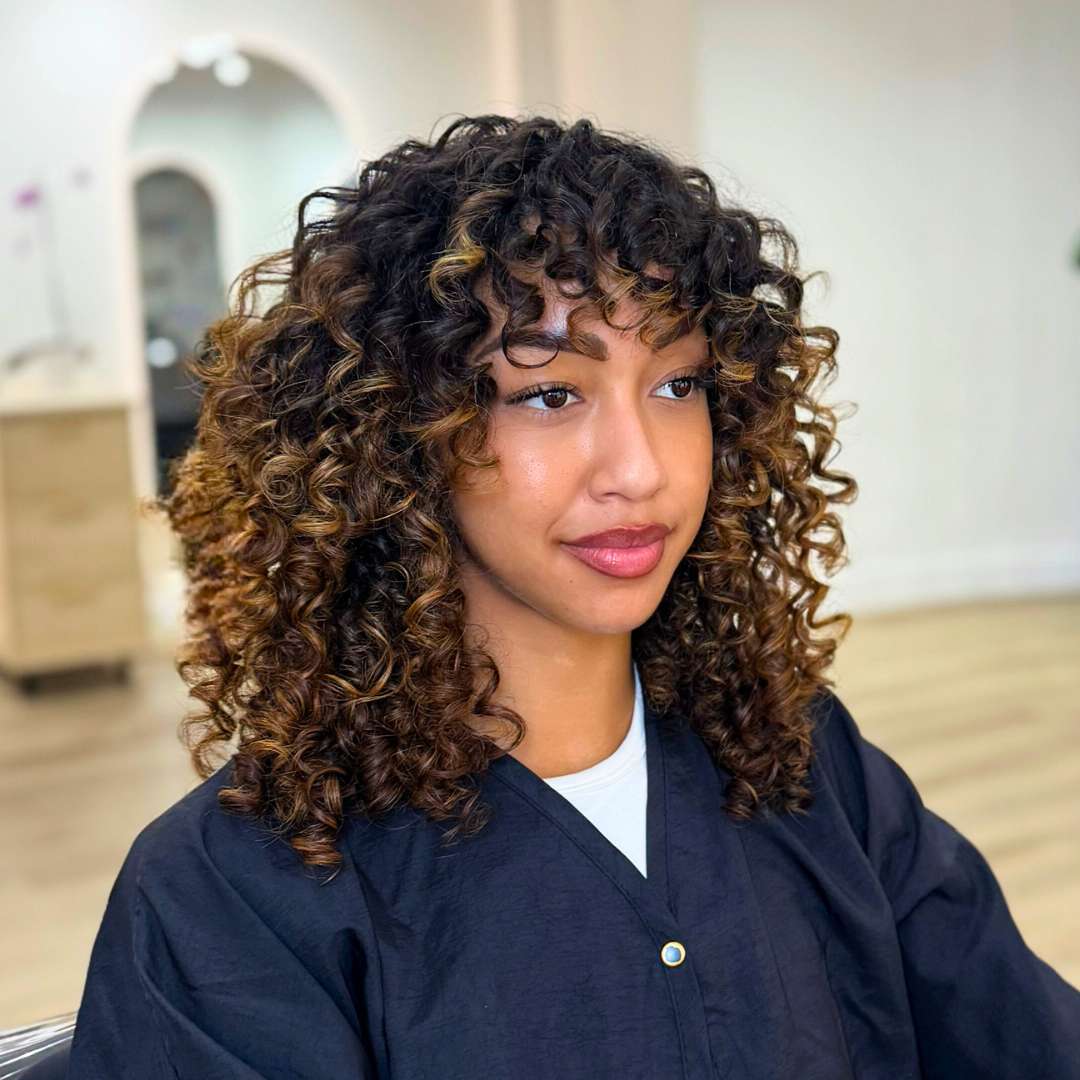 Finished curly hairstyle showcasing defined, voluminous curls after salon treatment