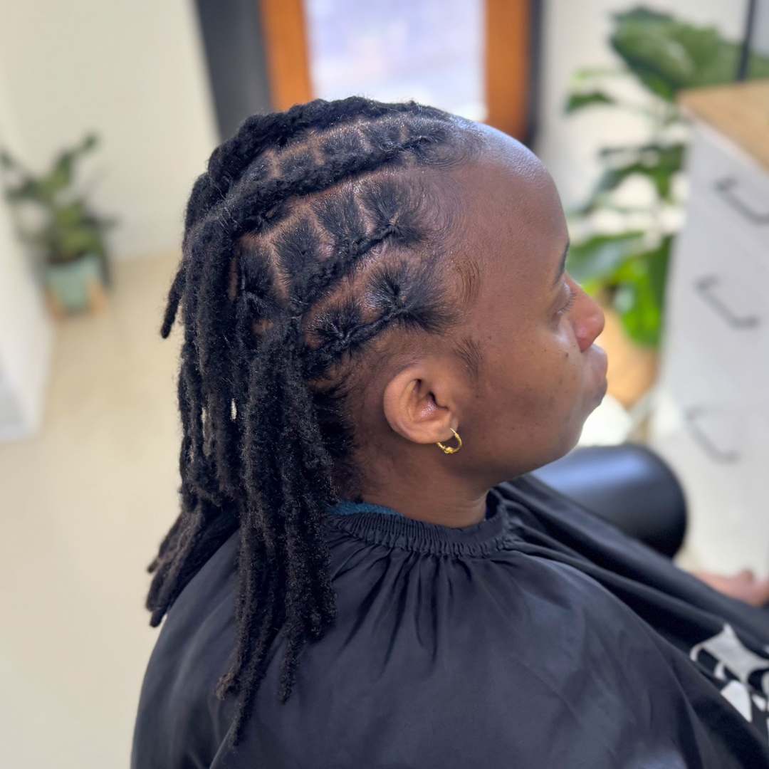 Side profile of a client with neatly retwisted medium-length locs at DES Curl Spa salon in Vancouver BC