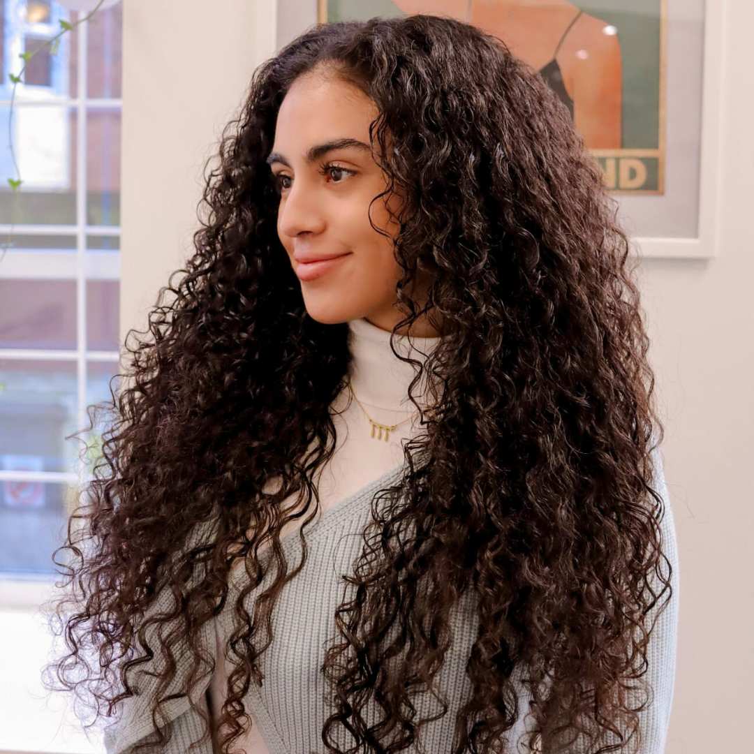Back view of defined curly hair with natural volume and shine at a Vancouver salon