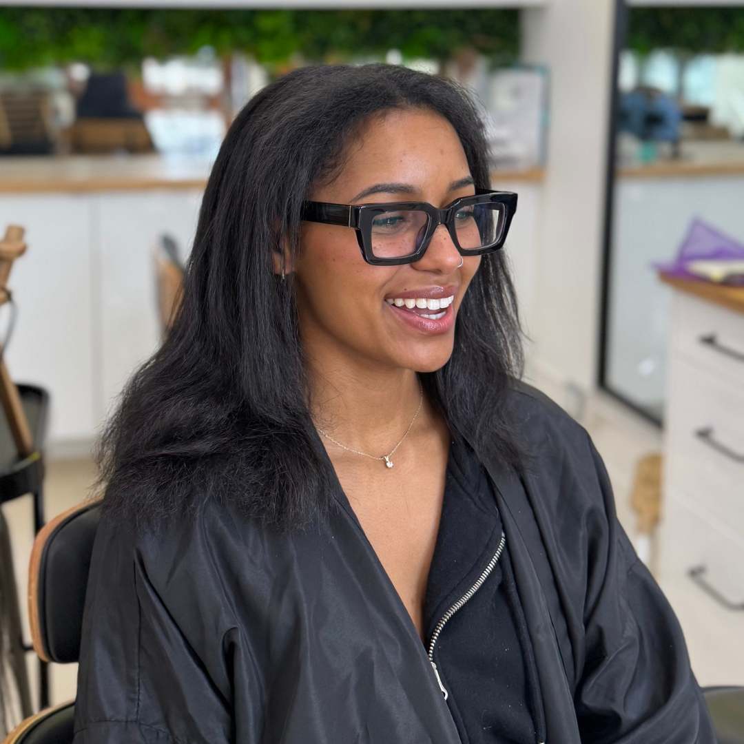 Model wearing long flowing box braids in a protective hairstyle, styled to preserve curl health and growth.