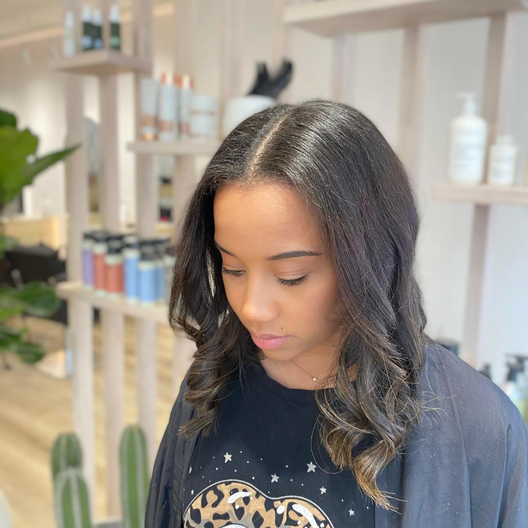 a woman displaying ilk press in curly hair salon