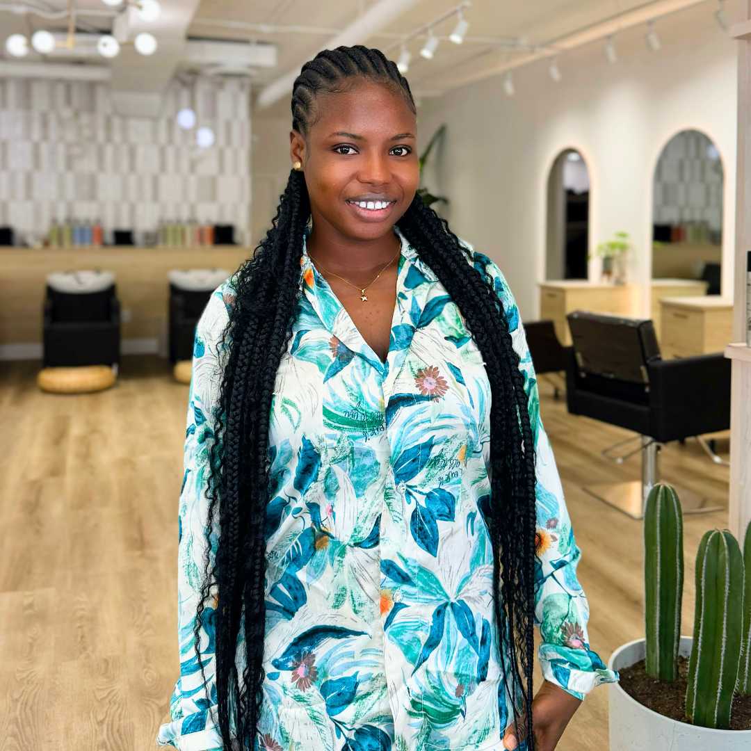 Portrait of Debbie, professional braider specializing in curly and natural hair styles"