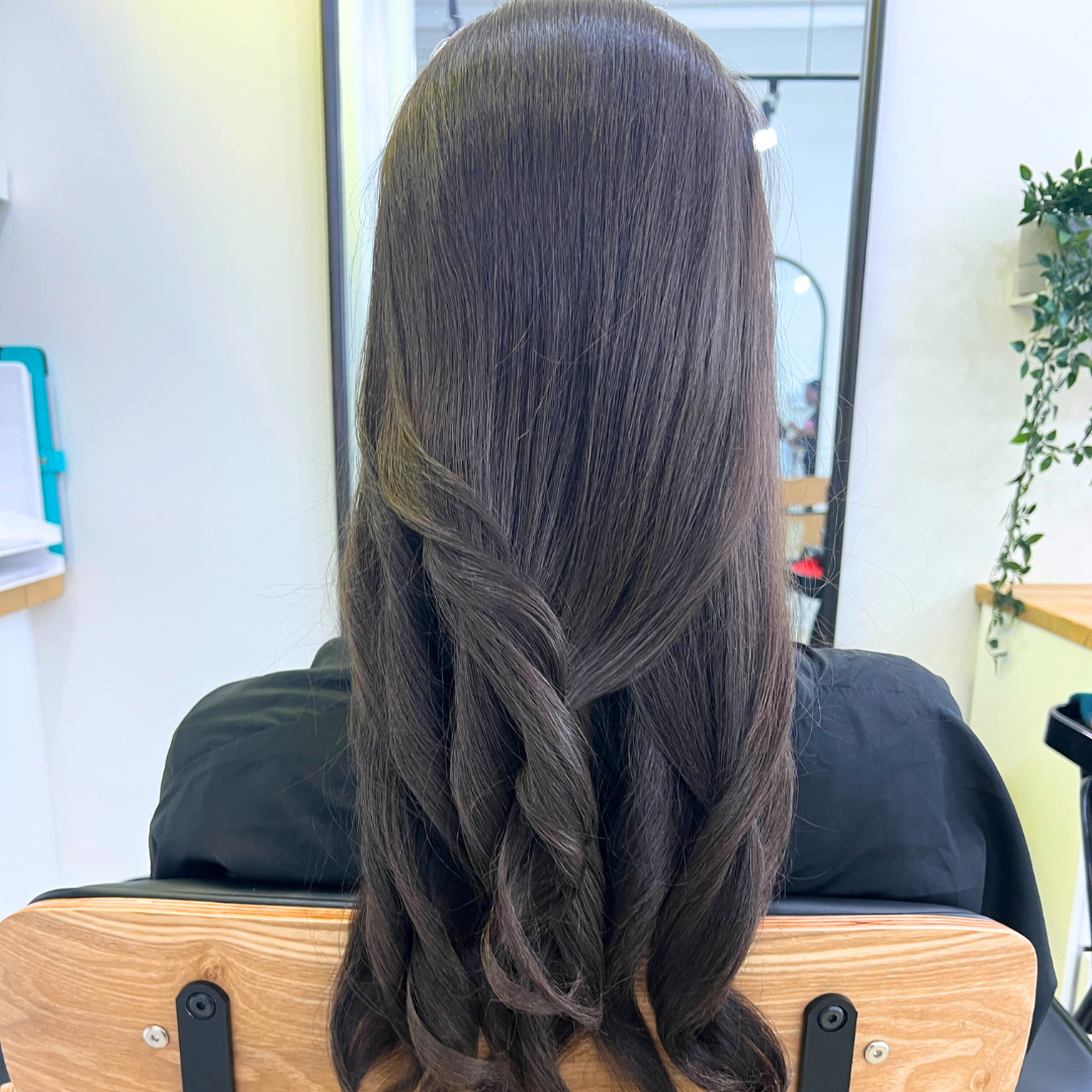 Woman sitting in a curly hair salon in vancouver to get a silk press 