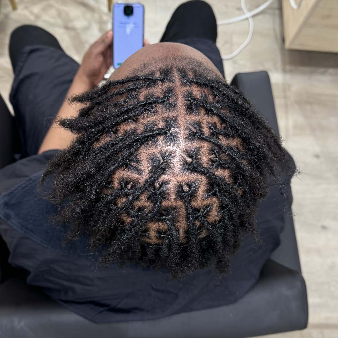 Top-down view of freshly retwisted locs with clean sectioning and defined parts — DES Curl Spa loc maintenance Vancouver